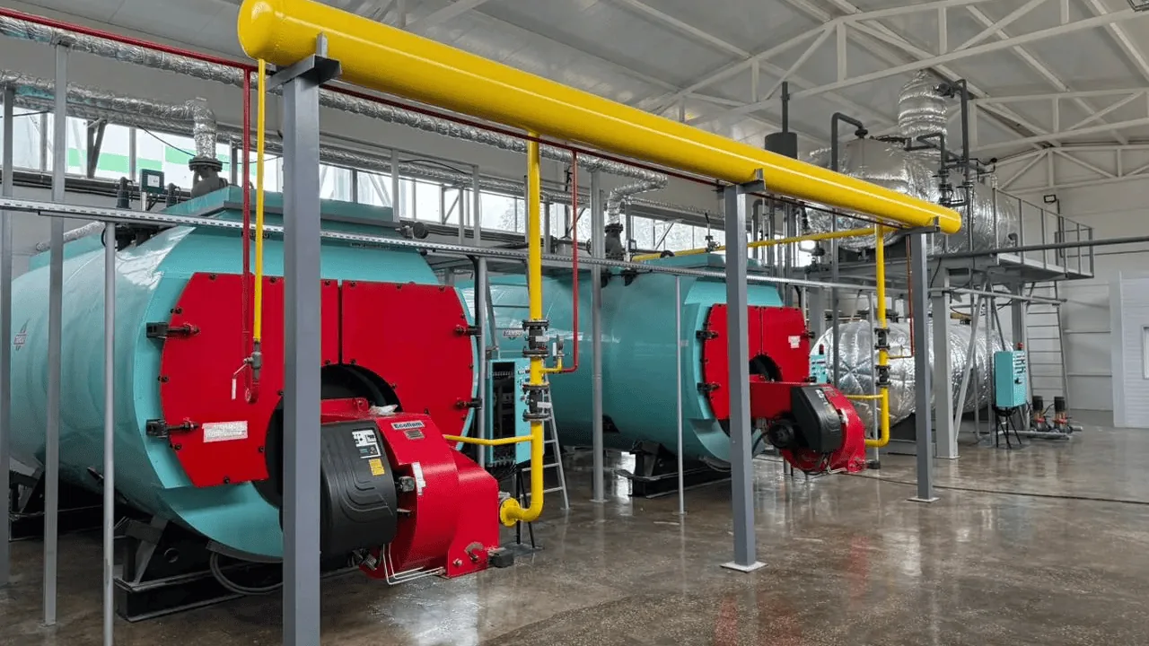 Two steam boilers with gas burners in an operating boiler house